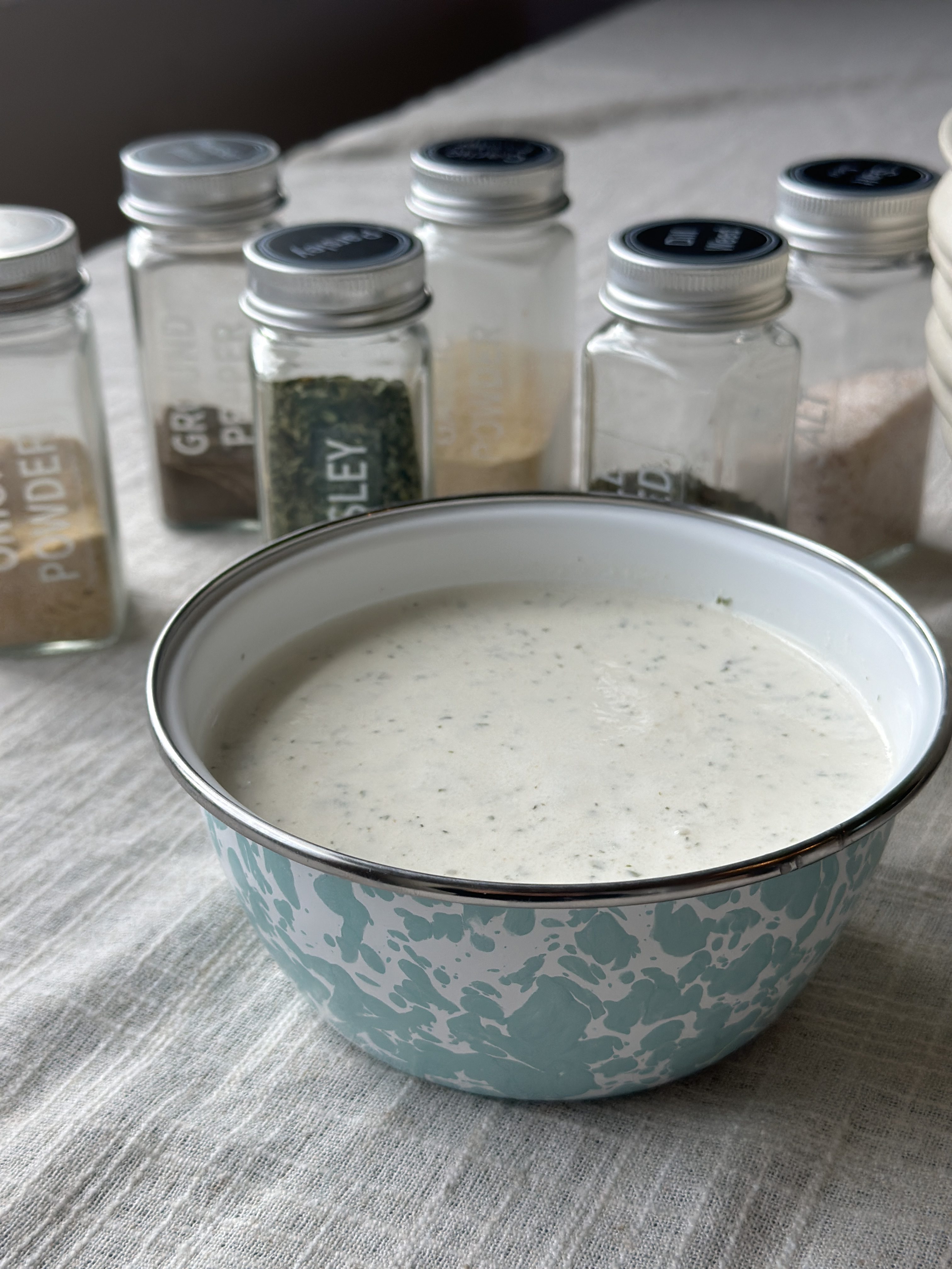 Restaurant style ranch dressing in a glass jar with dried herbs, ready for dipping and drizzling.